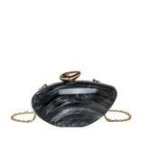 Oval shell acrylic evening bag in black with gold chain, perfect for evening occasions.