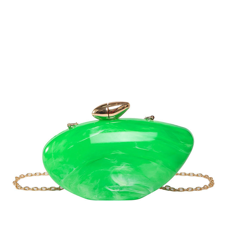 Oval shell acrylic evening bag in vibrant green color with a gold clasp and chain for an elegant touch.