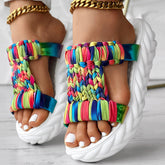 Braided summer sandals with colorful rainbow pattern and thick white sole for stylish summer wear.