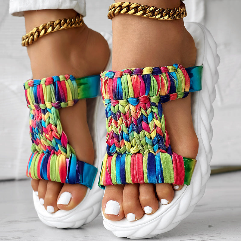 Braided summer sandals featuring a colorful rainbow stripe pattern and a thick sole for comfort and durability.