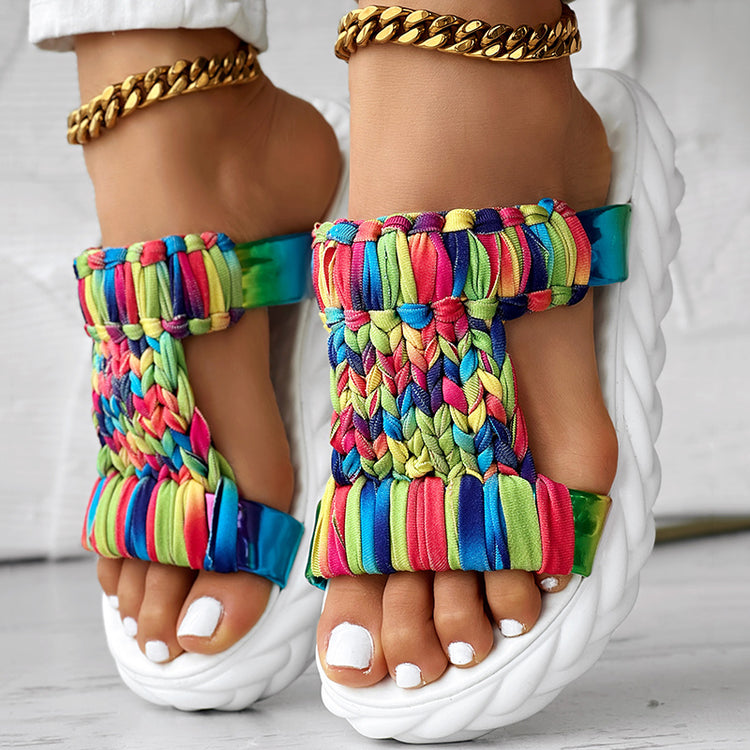 Braided summer sandals featuring a colorful rainbow stripe pattern and a thick sole for comfort and durability.