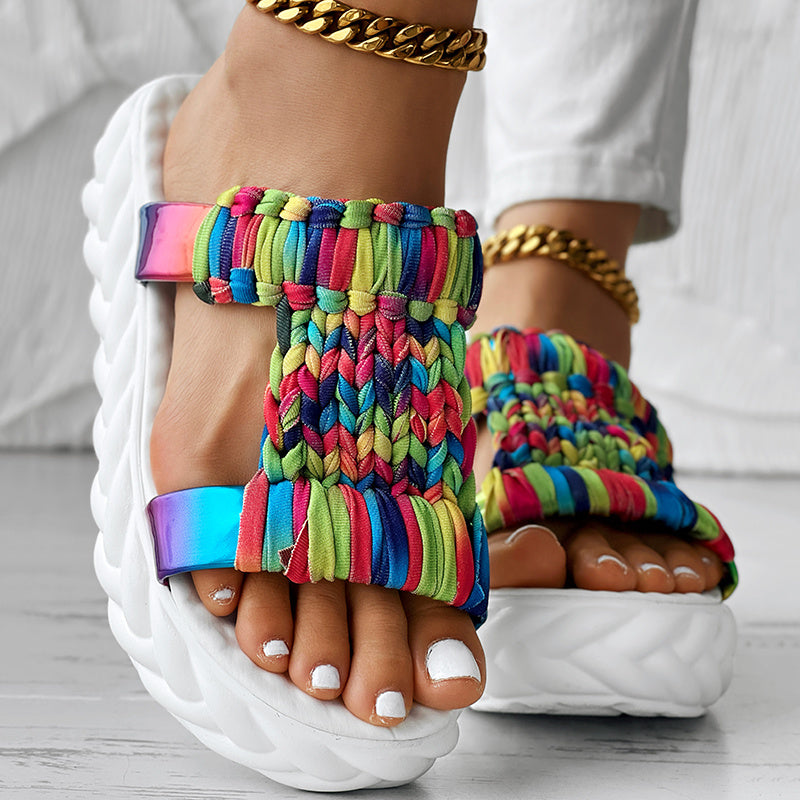 Braided summer sandals with a colorful rainbow stripe pattern and a thick white sole for comfort and style.