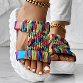 Braided summer sandals with a colorful rainbow stripe pattern and a thick white sole for comfort and style.
