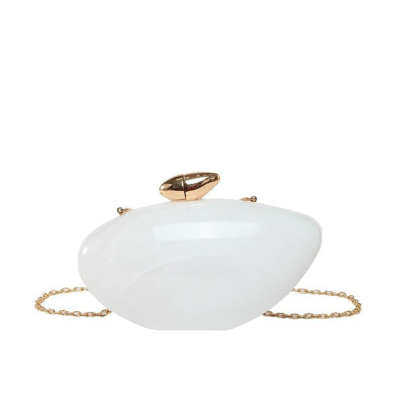 Oval shell acrylic evening bag in white color with a gold clasp and chain strap.